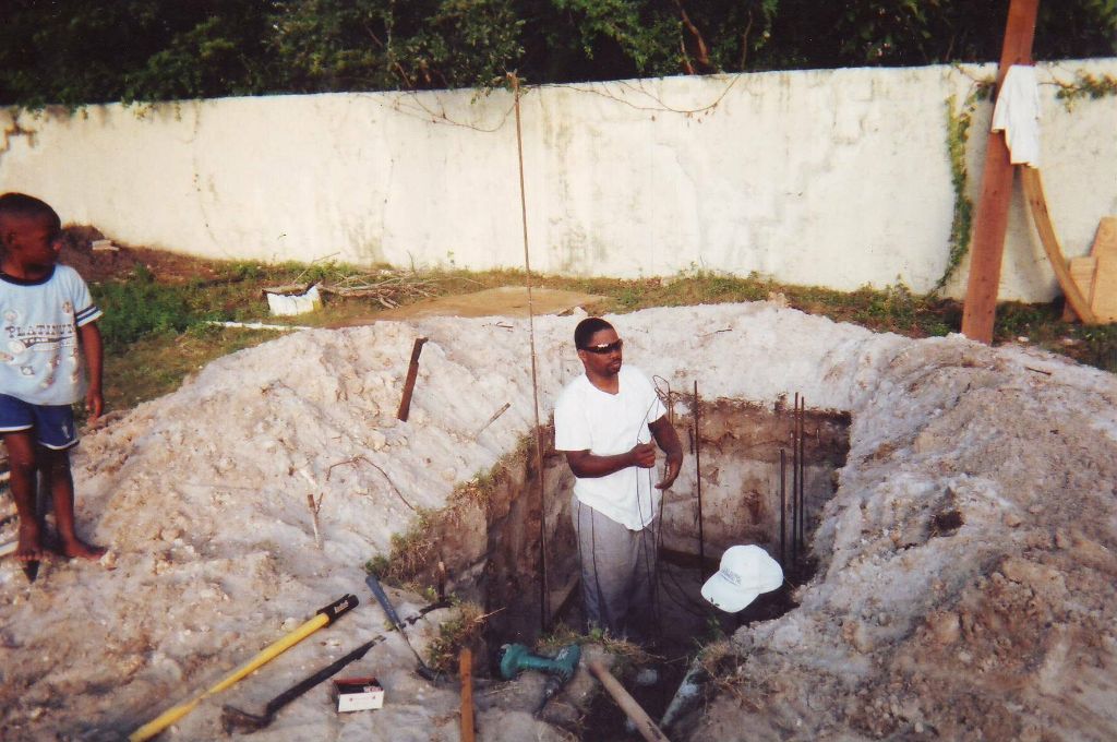 Prince Odulani Ibikunle doing hands-on construction work — foundation excavation